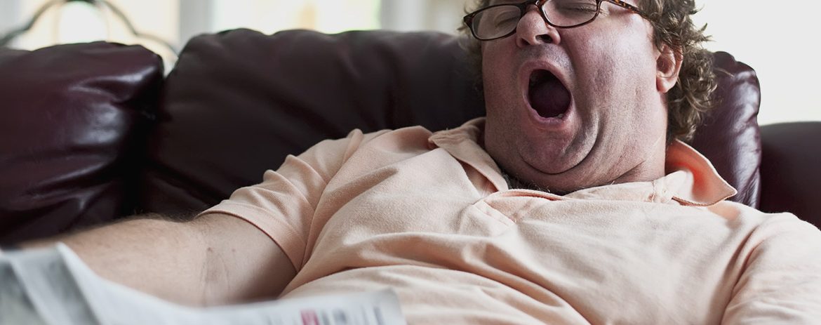 Lazy man yawning on couch